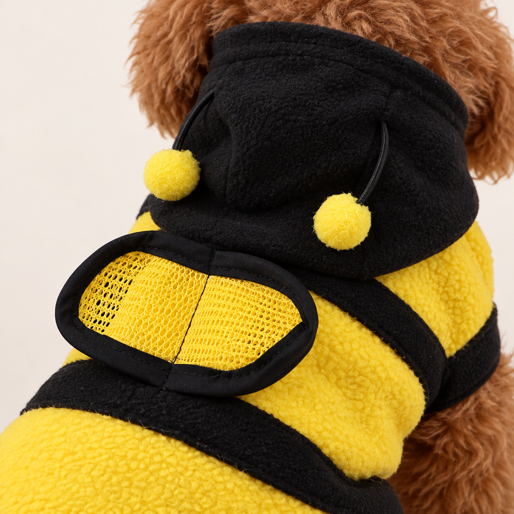 Närbild på meshvinge, fleece och pomponger på bihoodie
