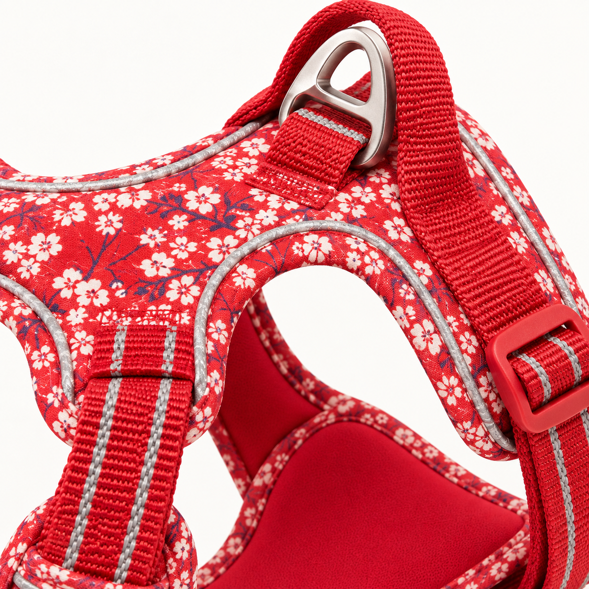 Detalj av rödblommig hundsele med reflex och koppelfäste