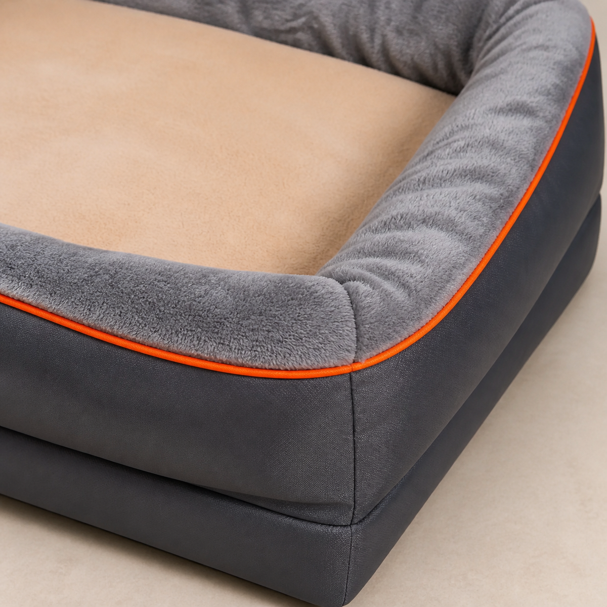 Närbild av grå plysch, orange passpoal och beige kudde